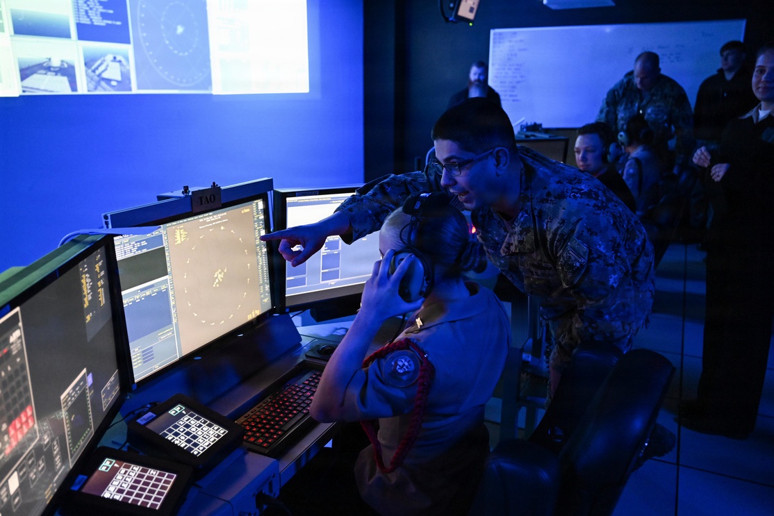 DAHLGREN, Va. (March 28, 2023) Surface Combat Systems Training Command (SCSTC) AEGIS Training and Readiness Center’s (ATRC) Lt. Tofik Benyaminov provides a training demonstration in the Reconfigurable Combat Information Center Trainer (RCT) to a cadet from Stafford High School’s Navy Junior Reserve Officer's Training Corps (NJROTC) during her visit to Naval Support Facility Dahlgren, March 28. The RCT is part of the Director, Surface Warfare’s (OPNAV N96) program of record, Surface Training Advanced Virtual Environment-Combat Systems (STAVE-CS), which was introduced in 2015 as a means to invest in training technologies, devices, and facilities to improve the effectiveness, efficiency, and availability of all surface training.