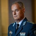A military officer in a dark teal/blue dress uniform is photographed in a formal portrait-style setting. His name tag reads 'RUSEV N.A.' and he wears Bulgarian Armed Forces insignia, including a shoulder patch with the Bulgarian flag. He has a serious expression and is wearing multiple service ribbons and decorations.