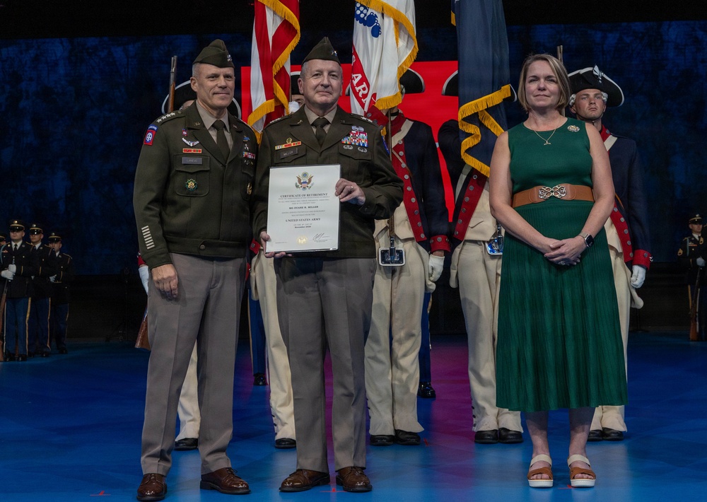A formal U.S. Army retirement ceremony is taking place on a stage. A uniformed officer in the center is holding a Certificate of Retirement, flanked by a senior officer on the left and a civilian woman in a green dress on the right. A military honor guard in historical uniforms stands in the background alongside U.S. and unit flags.