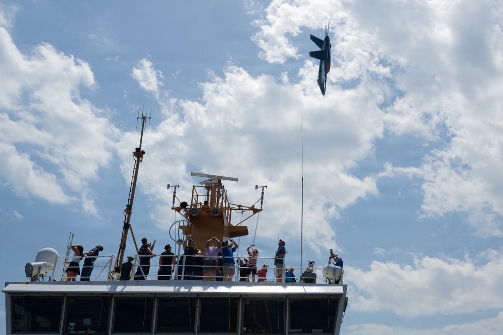 U.S. Navy Blue Angels F/A-18 Super Hornet flies over the U.S. Coast Guard Cutter Barbara Mabrity