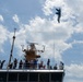 U.S. Navy Blue Angels F/A-18 Super Hornet flies over the U.S. Coast Guard Cutter Barbara Mabrity