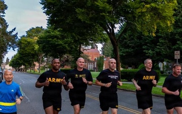 Senior officers conduct physical training during a visit from distinguished visitors at JBLM