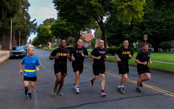 Senior officers conduct physical training during a visit from distinguished visitors at JBLM