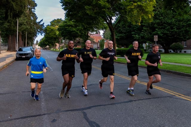 Senior officers conduct physical training during a visit from distinguished visitors at JBLM