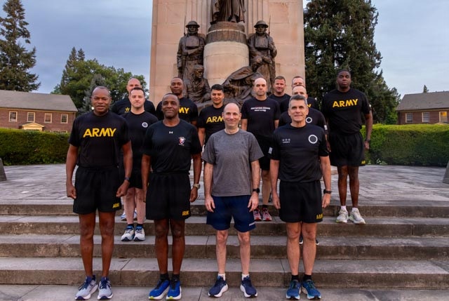 Senior officers conduct physical training during a visit from distinguished visitors at JBLM