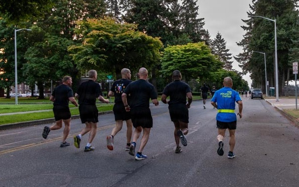 Senior officers conduct physical training during a visit from distinguished visitors at JBLM