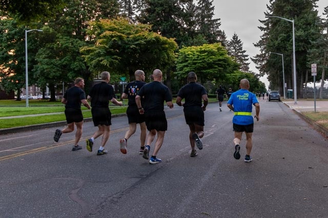 Senior officers conduct physical training during a visit from distinguished visitors at JBLM