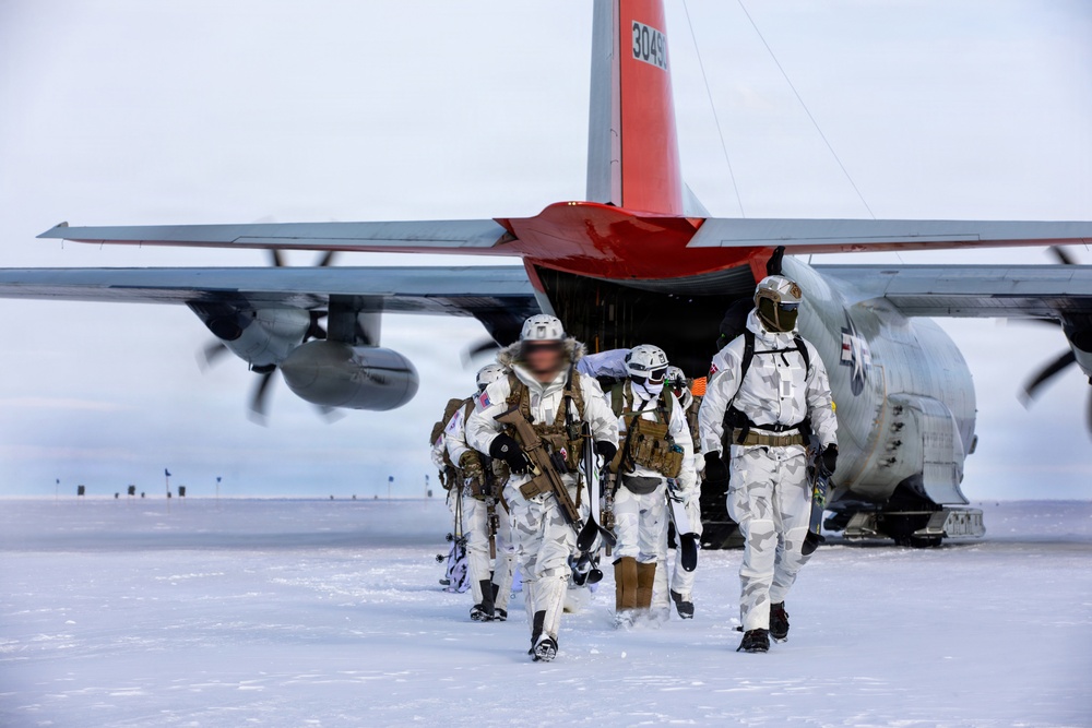A group of military personnel in white winter camouflage uniforms are disembarking from a military transport aircraft onto a snow-covered surface. The aircraft appears to be a C-130 Hercules variant with a distinctive red tail section and the partial serial number '3049' visible. The scene depicts an arctic or polar military operation, with personnel carrying weapons and tactical gear.