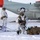 Green Berets, Danish SOF Ski Across Greenland Ice Cap During Operation Apex Indigo Military personnel in white winter camouflage gear are conducting cold-weather operations on a snow-covered surface near a U.S. Air National Guard aircraft. The aircraft bears the inscription 'NEW YORK AIR' and displays a U.S. Air Force roundel insignia. Soldiers are equipped with weapons, skis, sleds, and tactical backpacks, suggesting an Arctic or winter warfare training exercise.