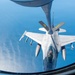 An aerial refueling operation is captured from the perspective of a tanker aircraft, showing an F-16 Fighting Falcon receiving fuel via a boom refueling system over open water. The fighter jet bears markings indicating it belongs to the Air National Guard (ANG) with a 'PA' designation, suggesting Pennsylvania Air National Guard. The aircraft is armed with multiple air-to-air missiles and external fuel tanks.