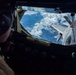 An aerial refueling operation is underway, viewed from inside a tanker aircraft's boom operator station. A fighter jet, identifiable as an F-16 Fighting Falcon, is positioned beneath the tanker's refueling boom to receive fuel. The markings 'ANG' (Air National Guard) and 'PA' (Pennsylvania) are visible on the tanker's tail assembly.
