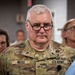 A U.S. Army soldier named Wead is prominently featured in the foreground, wearing OCP (Operational Camouflage Pattern) uniform with chaplain insignia (cross symbols) visible on the collar. He is wearing black-framed glasses and has a serious expression. Several civilians and at least one other religious figure are visible in the blurred background.