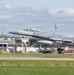 An F-16 Fighting Falcon jet fighter is captured during takeoff or landing on a runway. The aircraft bears tail markings 'AC 366' and 'AF 86' with a 'New Jersey' designation, identifying it as belonging to the New Jersey Air National Guard. Ground support equipment and airport infrastructure are visible in the background.