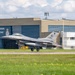 A U.S. Air Force F-16 Fighting Falcon (tail code AC, serial AF 85-366) is captured during takeoff or landing roll on a runway. The aircraft is in front of a Canadian military hangar marked 'Escadron 425 ETAC' with a Royal Canadian Air Force insignia visible. The setting appears to be a joint or visiting operation at a Canadian Forces base.