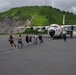 Coast Guard personnel compete to pull an HC-130J Super Hercules airplane in Kodiak, Alaska