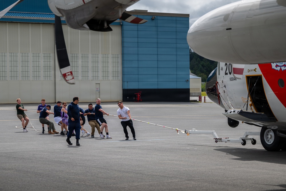 Coast Guard personnel compete to pull an HC-130J Super Hercules airplane in Kodiak, Alaska