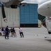Coast Guard personnel compete to pull an HC-130J Super Hercules airplane in Kodiak, Alaska