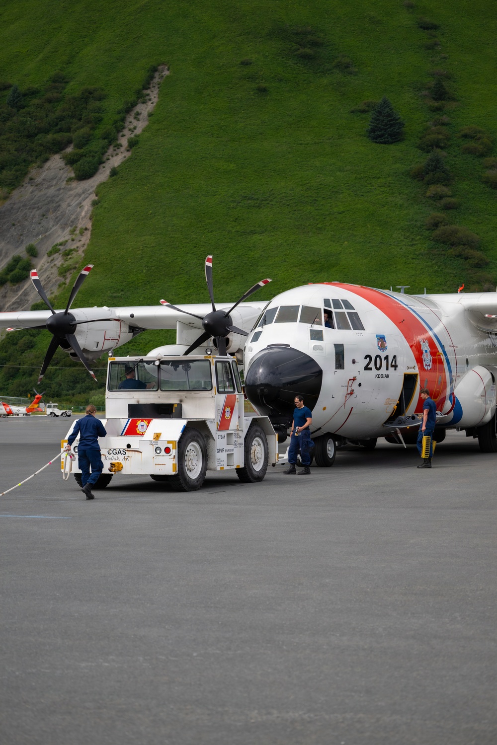 Coast Guard personnel compete to pull an HC-130J Super Hercules airplane in Kodiak, Alaska