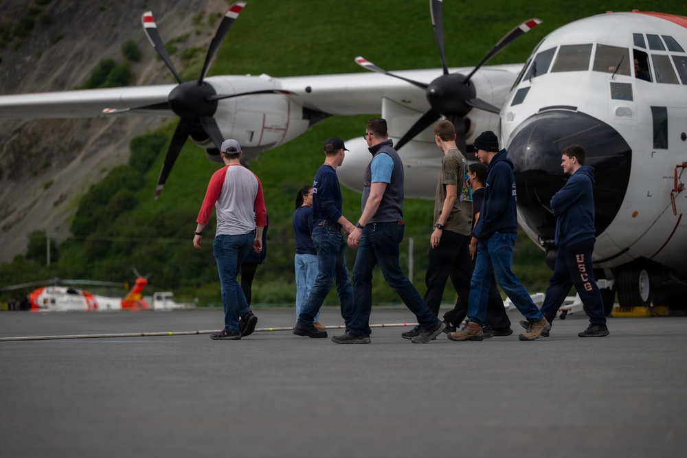 Coast Guard personnel compete to pull an HC-130J Super Hercules airplane in Kodiak, Alaska