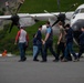 Coast Guard personnel compete to pull an HC-130J Super Hercules airplane in Kodiak, Alaska