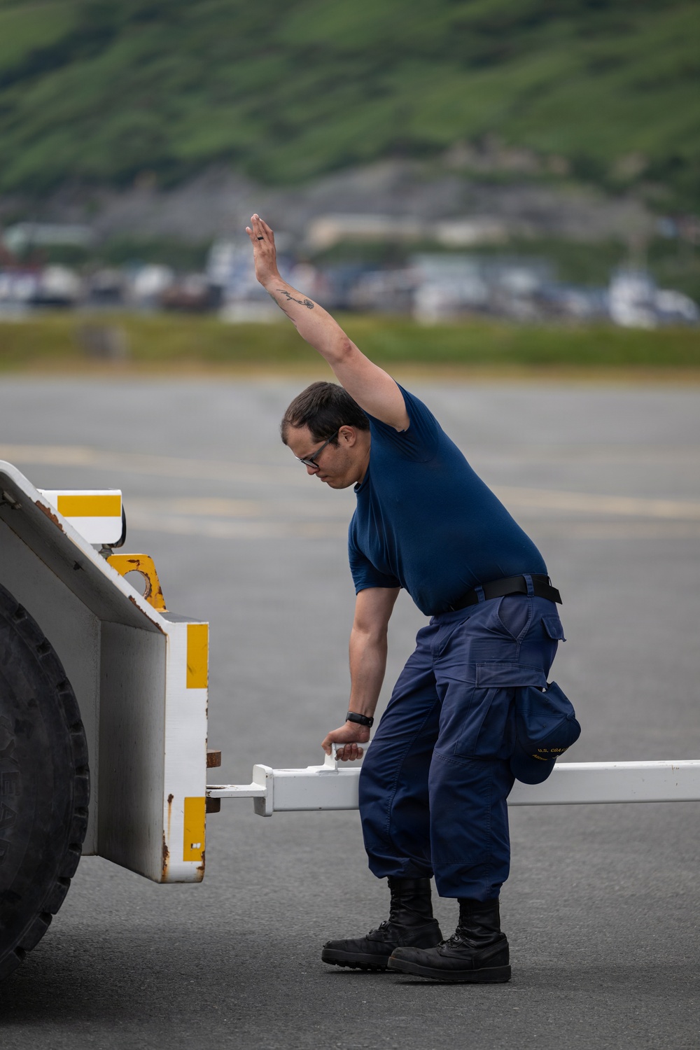 Coast Guard personnel compete to pull an HC-130J Super Hercules airplane in Kodiak, Alaska