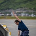 Coast Guard personnel compete to pull an HC-130J Super Hercules airplane in Kodiak, Alaska