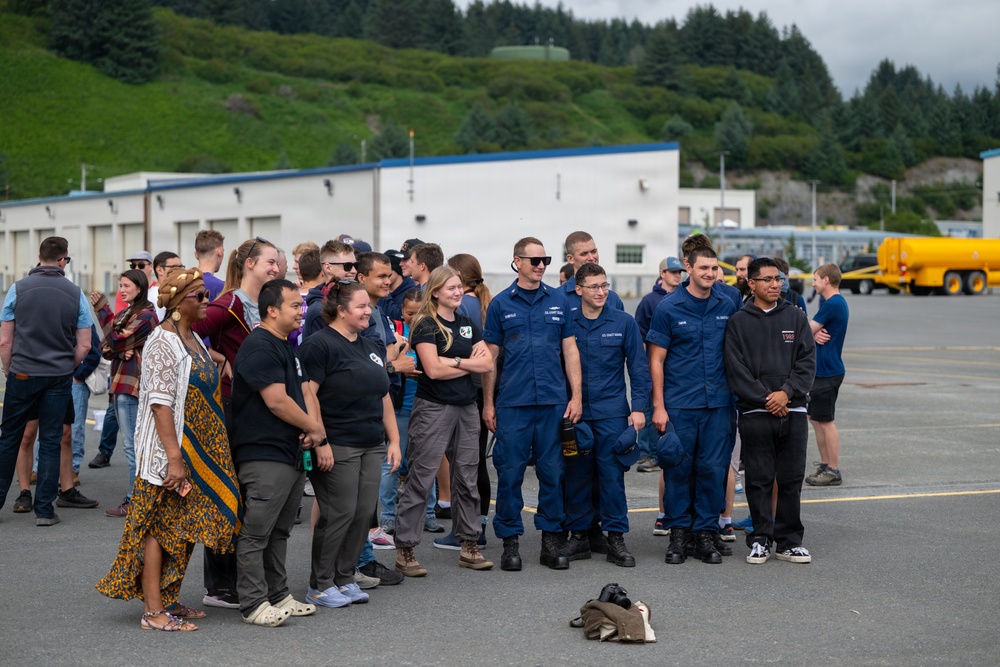 Coast Guard personnel compete to pull an HC-130J Super Hercules airplane in Kodiak, Alaska