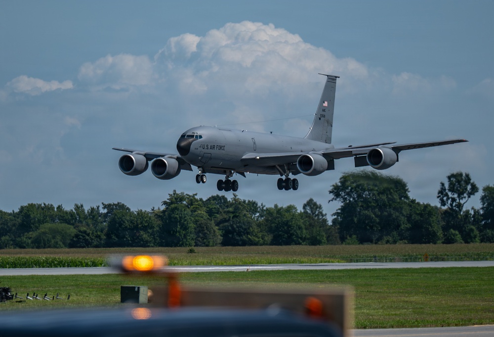 A U.S. Air Force KC-135 Stratotanker aerial refueling aircraft is captured on final approach to land at an airfield. The aircraft is in standard gray livery with 'U.S. AIR FORCE' markings clearly visible on the fuselage. Landing gear is fully deployed, indicating imminent touchdown.