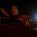 A U.S. Navy F-35C Lightning II stealth fighter jet (Bureau Number 307) is photographed on what appears to be an aircraft carrier flight deck during nighttime operations. The tail markings show 'NF' squadron codes and the number '307', with a squadron insignia visible on the tail fin. Ground crew personnel are visible working around the aircraft under low-light conditions.