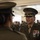 Alpha Company Battalion Commander’s Inspection A U.S. Marine Corps officer in Service 'C' uniform with significant medal ribbons and rank insignia is engaged in conversation with another uniformed Marine. The officer facing the camera wears a peaked cap with gold scrambled eggs indicating senior officer rank, along with multiple service ribbons and decorations. The setting appears to be an indoor military facility with additional uniformed personnel visible in the background.