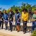 A ribbon-cutting ceremony is taking place at what appears to be a U.S. Army memorial or service location in Hillsborough County, Florida. Six individuals, including a uniformed fire official and several dignitaries, are cutting a purple ribbon simultaneously. A bronze equestrian statue is visible in the background, suggesting this is a dedication or grand opening event.