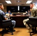 A formal military meeting is taking place in a conference room between personnel wearing Republic of Korea (ROK) Air Force uniforms and a U.S. Army soldier in MultiCam/OCP camouflage. The two primary figures are seated facing each other across a large conference table, suggesting a bilateral military discussion or briefing. Additional personnel, including civilians and uniformed individuals, are seated around the table taking notes.