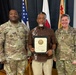 Three individuals pose for a formal photo at what appears to be a U.S. Army recognition ceremony. The civilian in the center, identified as Lawrence L. Brown on the certificate he holds, is being honored for Thirty-Five Years of service to the United States Army. He is flanked by two U.S. Army soldiers in MultiCam uniforms, identified by name tapes as Davis (left) and Johnson (right).