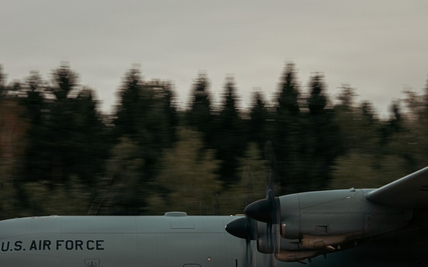 A U.S. Air Force C-130 Hercules military transport aircraft is taxiing or rolling on a runway or unpaved airstrip. The aircraft bears the markings 'U.S. AIR FORCE' and the tail number '4631' on its fuselage. The image was taken with a panning technique, resulting in motion blur in the background while the aircraft remains relatively sharp.
