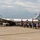 A large vintage American military bomber aircraft, serial number 469972, is on static display at what appears to be an airshow or military aviation event. A large crowd of visitors is lined up along the length of the aircraft on a concrete tarmac. The aircraft displays USAF markings including a star-and-bar insignia and red identification stripes, consistent with a B-29 Superfortress.
