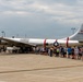 A large vintage American military bomber aircraft, serial number 469972, is on static display at what appears to be an airshow or military aviation event. A large crowd of visitors is lined up along the length of the aircraft on a concrete tarmac. The aircraft displays USAF markings including a star-and-bar insignia and red identification stripes, consistent with a B-29 Superfortress.