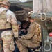 The image shows U.S. Army soldiers in OCP (Operational Camouflage Pattern) uniforms interacting with two civilian women inside or near a military vehicle, likely a HMMWV (Humvee). The soldiers appear to be giving the civilians a demonstration or familiarization tour of the vehicle's interior. A unit patch consistent with the 1st Cavalry Division is visible on one soldier's sleeve.