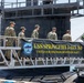 The image shows U.S. Navy personnel in camouflage uniforms boarding or standing on the USS Springfield SSN 761, a Los Angeles-class attack submarine. A prominent banner on the gangway reads 'USS SPRINGFIELD SSN 761 - UNITED FOR FREEDOM, READY FOR WAR!!!' along with the ship's insignia. The scene appears to be at a naval port or pier during daylight hours.