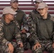 A group of military personnel wearing South Korean Army camouflage uniforms are seated on bleachers or stadium-style seating. Two soldiers in the foreground appear to be engaged in conversation, while others sit attentively in the background. The South Korean flag (Taegukgi) patches are clearly visible on their left sleeves.