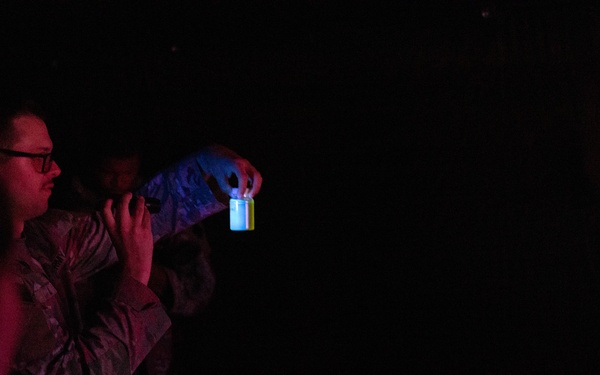 U.S. Army Spc. Craig Lee shines a light into a jar