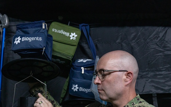 U.S. Navy Lt. Cmdr. Adam Salyer works with a mosquito trap