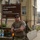 12th Combat Aviation Brigade hosts Danish Flyver March A male soldier in U.S. Army combat uniform stands with arms crossed in front of the 12th Combat Aviation Brigade Headquarters sign, numbered 5850. He is wearing sunglasses, a tactical backpack, and has visible tattoos on his right forearm. The setting appears to be a military installation, likely in Europe based on the architectural style.