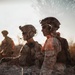 A double-exposure or composite photograph showing military personnel in full tactical gear in an arid outdoor environment. At least three soldiers are visible wearing combat helmets, body armor, and communication headsets. The layered photographic technique creates a ghostly, semi-transparent effect overlapping multiple exposures of the same or different subjects.