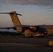 A U.S. Air Force C-17 Globemaster III military cargo aircraft is parked on a tarmac at dusk or dawn. The aircraft belongs to the New York Air National Guard, based at Stewart Air National Guard Base, with tail number 0188. The warm golden light of the low sun illuminates the aircraft against a partly cloudy sky.