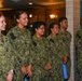 Six U.S. Navy personnel in NWU Type III (woodland digital camouflage) uniforms are standing in a line inside what appears to be a formal indoor military facility. The group consists of four women and two men, all appearing relaxed and smiling, suggesting a ceremonial or recognition event. Name tapes visible include McBride, Wellborn, Velasquez, Brown, Ramirez, and Wells.