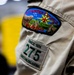 A close-up photograph of a Boy Scout uniform sleeve displaying two patches. The upper patch identifies the 'Last Frontier Council, Oklahoma' council patch with an embroidered scene. The lower patch identifies Troop 275, based in Checotah, Oklahoma, established since 1974.