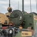 Two soldiers are positioned in or on a military armored vehicle, likely a Bradley Fighting Vehicle or similar tracked platform. The vehicle displays name placards reading 'PY2 RUSSELL' and 'SSG HAWTHORNE', indicating crew assignments. The scene appears to be a field training exercise or operational deployment.