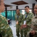 A U.S. Air Force officer in OCP (Operational Camouflage Pattern) uniform is engaged in conversation with several military personnel wearing TNI AU (Indonesian Air Force) uniforms. The setting appears to be an indoor meeting or conference facility, suggesting a bilateral or multilateral military engagement. The interaction appears cordial and professional in nature.