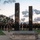 Victory Reception Company Welcome Run A large group of U.S. Army personnel dressed in black PT (physical training) uniforms are assembled around a memorial monument featuring two tall dark reflective pillars, likely representing the Twin Towers of the World Trade Center. The monument's base bears the inscription 'DONATED BY AUSA AND,' suggesting it was donated by the Association of the United States Army. The scene appears to be a 9/11 remembrance ceremony taking place at dusk or dawn on what appears to be a military installation.