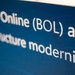 The image shows a close-up photograph of a digital screen displaying white text on a dark blue background. The visible text references 'Online (BOL) and' on the first line, followed by 'Infrastructure modernization' on subsequent lines. The text appears to be part of a presentation slide or webpage, partially cropped at the edges.